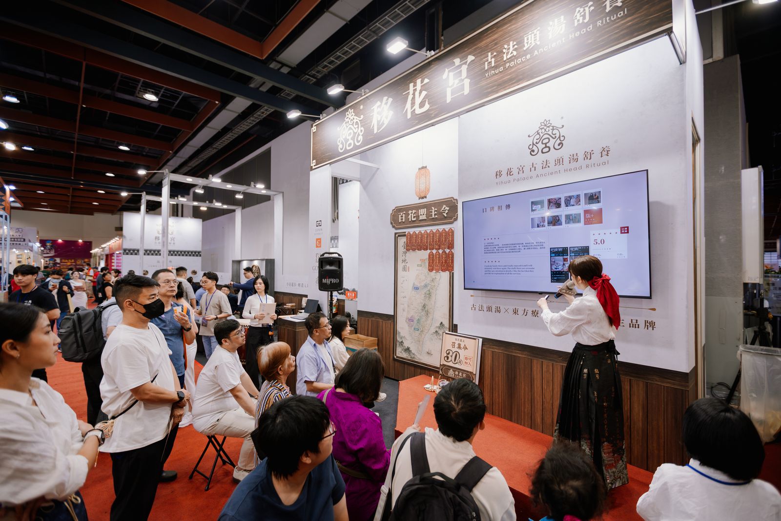 移花宮舒養師在台北國際連鎖加盟創業展展區向參觀民眾解說古法頭湯舒養
