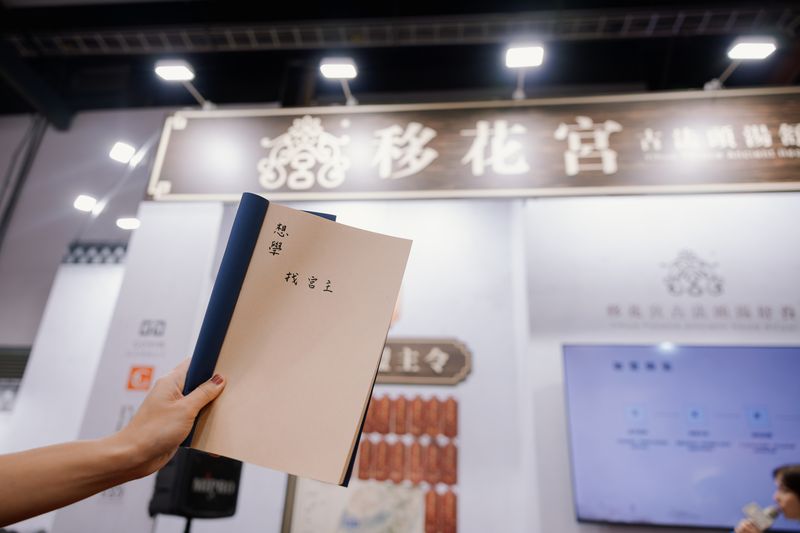 展區招牌前舉起的移花宮線裝冊，封面寫著想學找宮主