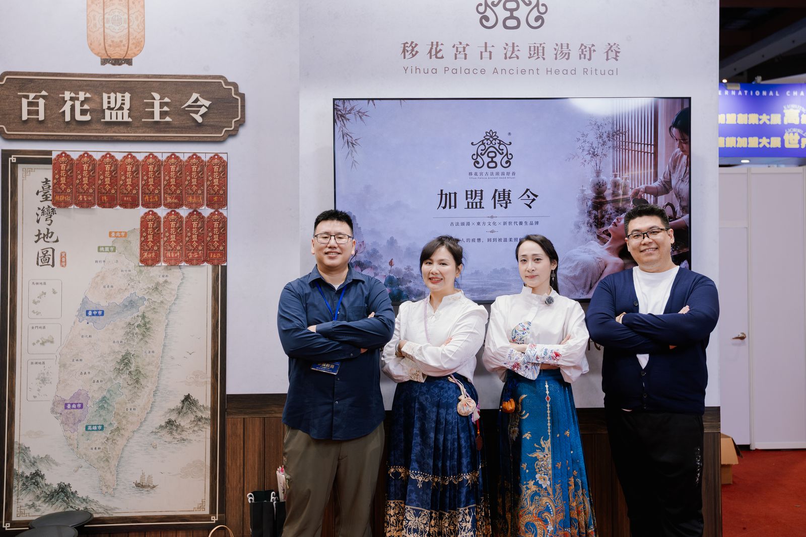 移花宮團隊在台北國際連鎖加盟創業展的加盟主視覺與百花盟主令台灣地圖展區前合影